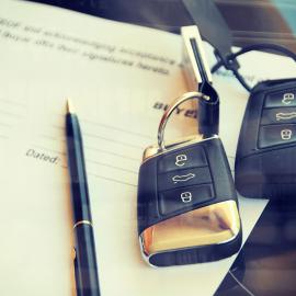 Una llave de coche, un bolígrafo y un papel cuidadosamente dispuestos sobre un escritorio, listos para su uso.