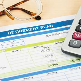Elementos esenciales de un plan de jubilación: calculadora, anteojos y bolígrafo. Estas herramientas ayudan a realizar cálculos y decisiones financieras.