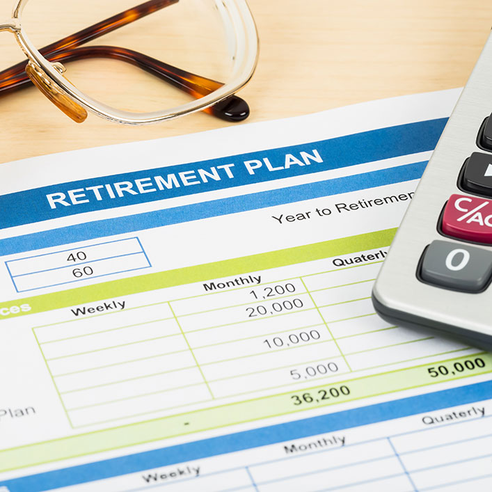 Elementos esenciales de un plan de jubilación: calculadora, anteojos y bolígrafo. Estas herramientas ayudan a realizar cálculos y decisiones financieras.